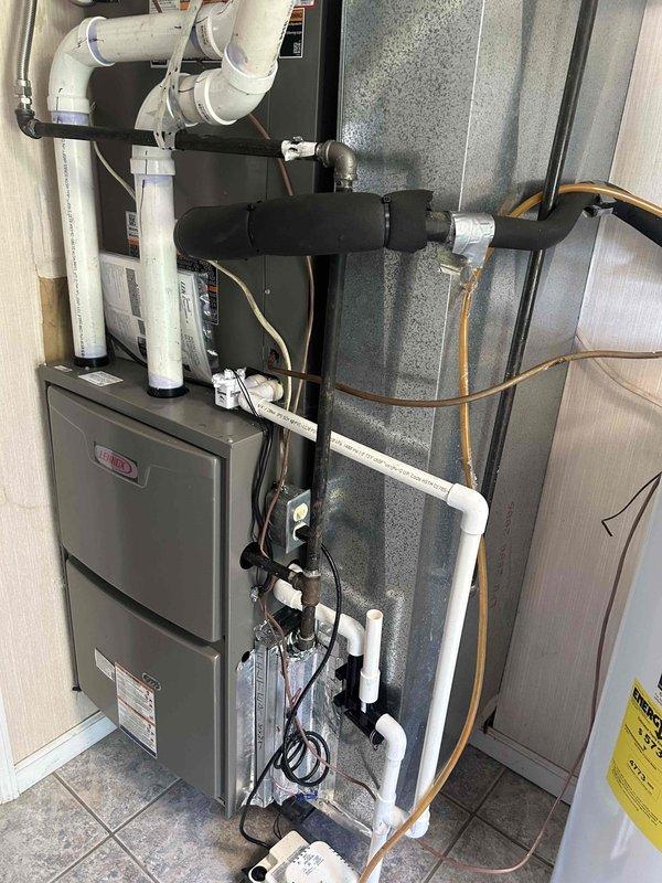 Completed full residential HVAC system installation featuring a Lennox 14.3 SEER2 3-ton single stage heat pump paired with a 110,000 BTU 96% efficiency single stage gas furnace. Removed and properly disposed of existing equipment, obtained applicable permits, and installed complete system with all necessary components and safety features.

Outdoor heat pump installation included setting unit on new concrete pad with snow legs for elevation, installed electrical whip kit with disconnect box for service accessibility, ran insulated refrigerant lines with inline filter, and completed all electrical connections per code requirements.

Indoor furnace installation positioned unit in utility space, installed transition to evaporator coil with standard-sized air filter rack for maintenance access, connected to existing flue piping with proper venting, installed PVC condensate drain system with trap and SS2 coil drain safety water sensor, added "Ceiling Saver" overflow drain pan equipped with s