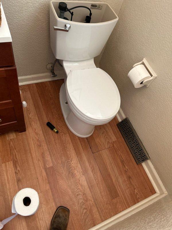 Responded to water leak at half bath toilet with intermittent leaking at base during flushing. Inspected toilet tank internal components and base seal area. Advised customer to utilize shut off valve to prevent further water damage until repairs can be completed. Documented conditions with photographs showing tank mechanism and surrounding area.