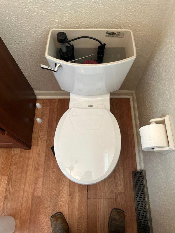 Responded to water leak at half bath toilet with intermittent leaking at base during flushing. Inspected toilet tank internal components and base seal area. Advised customer to utilize shut off valve to prevent further water damage until repairs can be completed. Documented conditions with photographs showing tank mechanism and surrounding area.