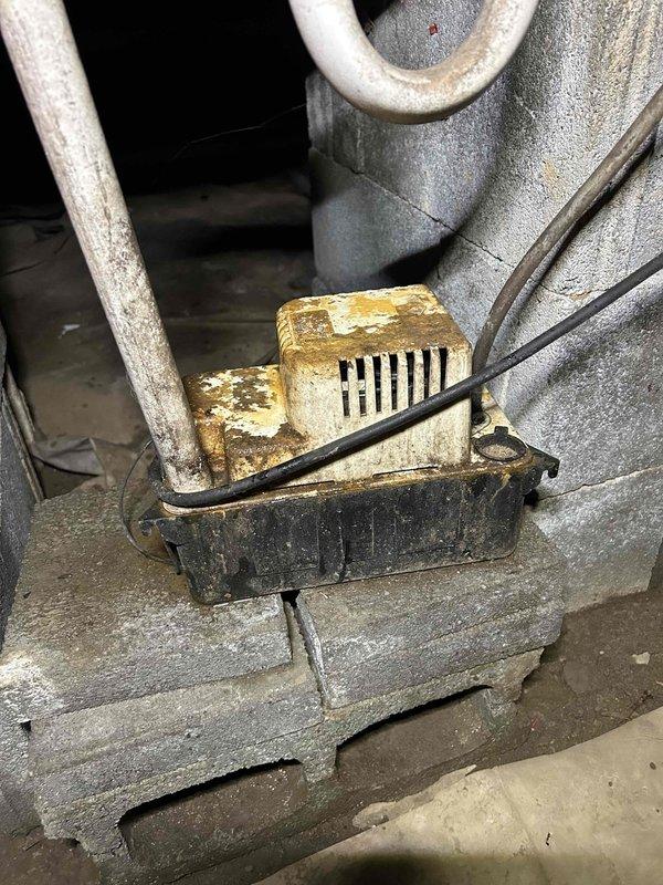 Responded to service call for dislodged HVAC vent in building addition. Upon inspection, found heavily corroded ventilation component with loose connection requiring securement. Assessed condensate pump system and associated drainage piping in utility area, noting significant corrosion on metal ductwork and moisture staining on concrete surfaces. Secured disconnected vent connection and verified proper system operation.