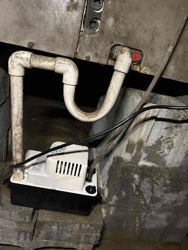 Responded to service call for dislodged HVAC vent in building addition. Upon inspection, found heavily corroded ventilation component with loose connection requiring securement. Assessed condensate pump system and associated drainage piping in utility area, noting significant corrosion on metal ductwork and moisture staining on concrete surfaces. Secured disconnected vent connection and verified proper system operation.