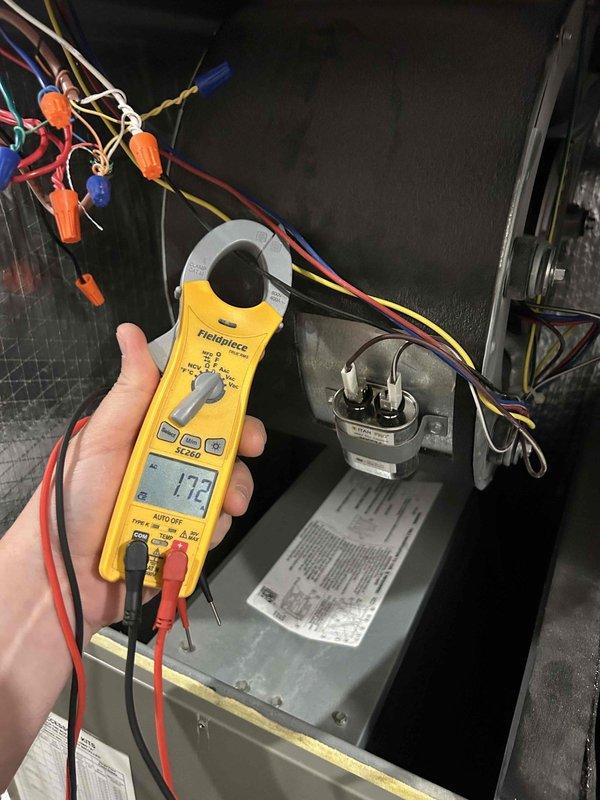 Responded to no cooling complaint on 2-year-old Lennox heat pump system with recurring low pressure fault that would reset and operate for a few hours before faulting again. Performed electrical diagnostics on indoor unit located in basement using clamp meter to measure amperage draw and verify proper operation of compressor and control board. Found system operating at 173 amps during testing, indicating electrical components were functioning within normal parameters at time of service call.