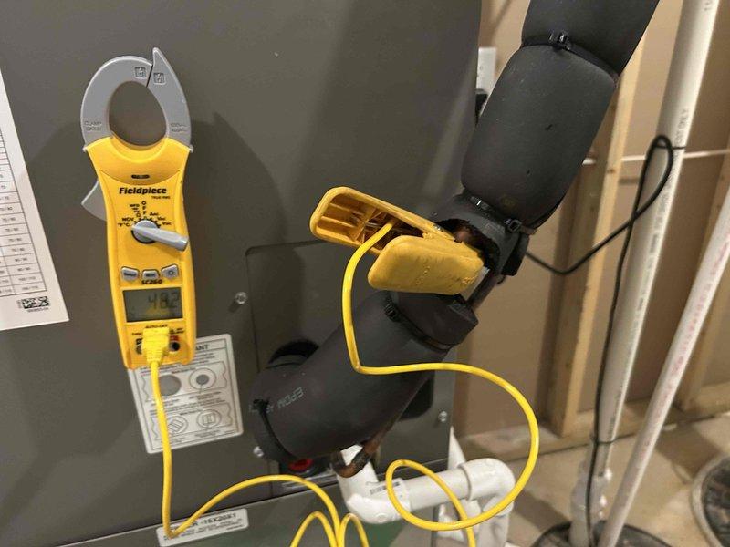 Responded to no cooling complaint on 2-year-old Lennox heat pump system with recurring low pressure fault that would reset and operate for a few hours before faulting again. Performed electrical diagnostics on indoor unit located in basement using clamp meter to measure amperage draw and verify proper operation of compressor and control board. Found system operating at 173 amps during testing, indicating electrical components were functioning within normal parameters at time of service call.