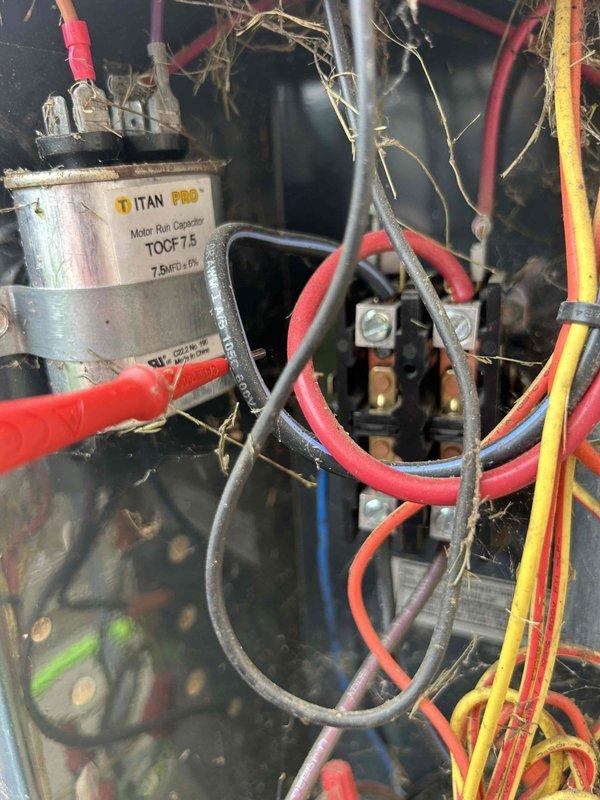 Responded to no cooling complaint on heat pump system. Upon arrival, found thermostat calling for cooling with indoor temperature at 78°F and setpoint at 70°F. Proceeded to outdoor unit for diagnostic evaluation. Discovered outdoor condensing unit contaminated with excessive debris, dried grass, and vegetation accumulated throughout electrical components and around contactor assembly. Located failed run capacitor (TITAN PRO TOCF15, 7.5µF/370V) preventing compressor operation. Removed debris from electrical compartment and surrounding components to ensure proper airflow and prevent future electrical issues. Replaced defective capacitor with new unit meeting manufacturer specifications. Verified all electrical connections secure and properly terminated. Tested system operation with compressor and condenser fan running normally. Confirmed cooling cycle engaging properly and refrigerant pressures within acceptable range. System restored to normal operation with adequate cooling capacity.