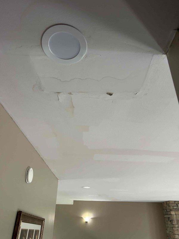 Responded to no cooling call on electric air conditioning system. Upon inspection, found condensate drain line completely clogged, preventing proper drainage and triggering safety float switch which shut down the system. Cleared blockage from condensate drain using appropriate tools and flushed line to restore proper flow. Verified drain line functionality and confirmed system returned to normal cooling operation. Noted evidence of previous water damage on ceiling near air handler location in attic, likely from overflow during drainage blockage. Air handler showed significant dust accumulation on top surface. Tested system operation after clearing drain and verified unit cycling properly with adequate airflow and cooling output.