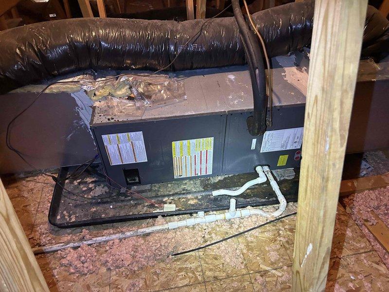 Responded to no cooling call on electric air conditioning system. Upon inspection, found condensate drain line completely clogged, preventing proper drainage and triggering safety float switch which shut down the system. Cleared blockage from condensate drain using appropriate tools and flushed line to restore proper flow. Verified drain line functionality and confirmed system returned to normal cooling operation. Noted evidence of previous water damage on ceiling near air handler location in attic, likely from overflow during drainage blockage. Air handler showed significant dust accumulation on top surface. Tested system operation after clearing drain and verified unit cycling properly with adequate airflow and cooling output.