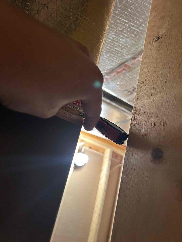 Responded to a non-cooling complaint on a 13-year-old AC unit. Upon inspection, accessed the attic space and measured existing insulation levels, which appeared inadequate based on the reflective radiant barrier material observed. Documented insulation conditions and measurements to assess potential contributing factors to the system's reduced cooling efficiency, as insufficient attic insulation can significantly impact AC performance and increase cooling loads on aging equipment.