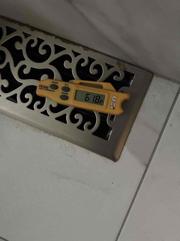 Responded to no cooling complaint on electric air conditioning system. Performed diagnostic testing and measured supply air temperatures at floor registers using calibrated digital thermometer. Initial supply air reading measured 61°F at decorative floor vent, with return air temperature at 79.2°F, indicating approximately 18.2°F temperature differential. Secondary measurements confirmed supply air temperature of 72.6°F at additional register location. Temperature split falls below optimal 15-20°F range expected for properly functioning residential cooling system, suggesting potential refrigerant charge issues, airflow restrictions, or compressor performance concerns requiring further diagnostic evaluation.