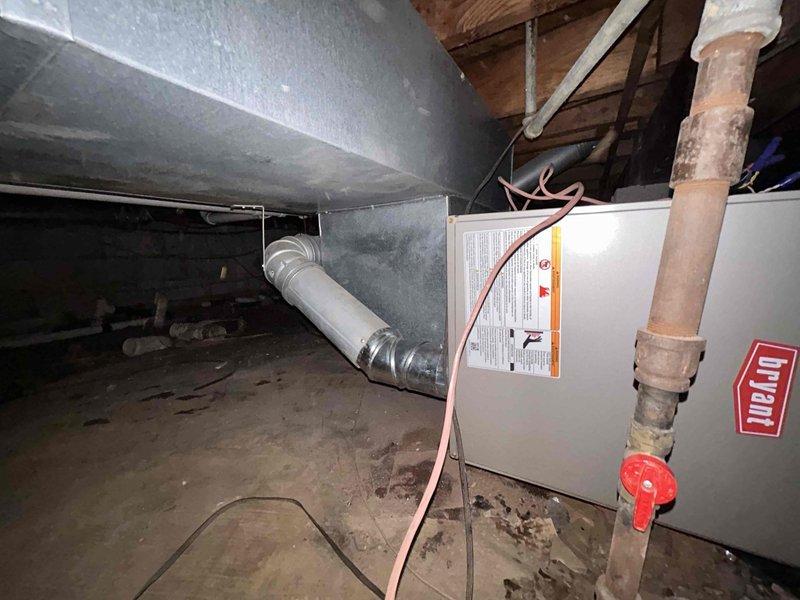 Successfully installed a Bryant Legacy 800SB36070M17 70,000 BTU 80% AFUE single-stage gas furnace in horizontal right configuration within crawl space. Removed and properly disposed of existing equipment, then positioned new unit on dirt floor beneath floor joists with appropriate clearances. Connected gas supply line with shutoff valve, installed copper refrigerant lines, and routed condensate drain tubing. Configured venting system per code requirements using single-wall 4" vent pipe with one elbow inside cabinet transitioning immediately to double-wall vent pipe, ensuring no wires or materials contacted vent components within unit cabinet. Connected supply and return ductwork using metallic flex duct with proper insulation. Completed all electrical connections and verified proper operation of blower motor, gas valve, and ignition system. Obtained necessary permits and ensured installation met all applicable building and mechanical codes for residential HVAC systems.
