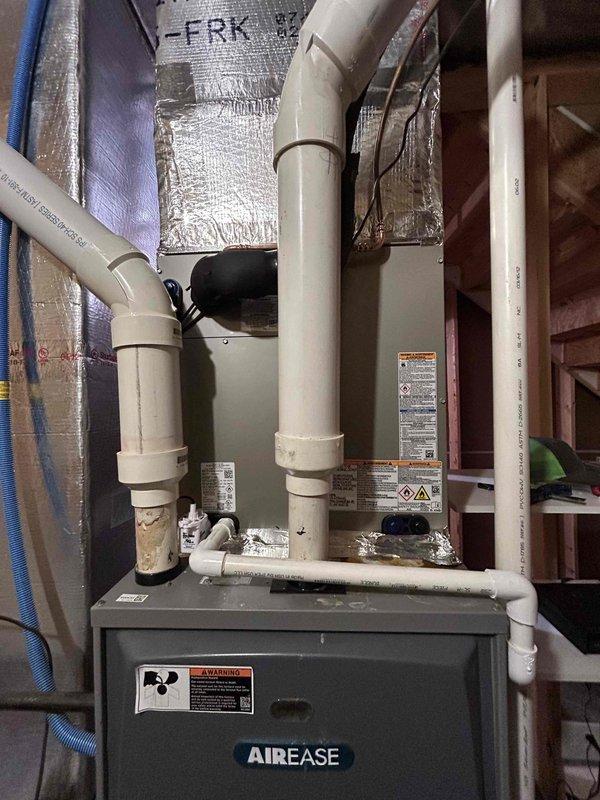 Completed residential HVAC installation of a Carrier 2-stage 18.2 SEER2 4-ton air conditioning system with matching evaporator coil. Installed AirEase model 26TPA848W003 outdoor condensing unit on new equipment pad with white gravel base adjacent to brick exterior. Basement evaporator coil model MA4821XMA installed with proper transition to existing ductwork. Installation included electrical whip kit, disconnect box, refrigerant line insulation, and filter drier. Installed SS2 coil drain safety water sensor and tested operation to verify proper function.

Replaced Air Scrubber bulb in upstairs system to restore air purification functionality. Installed T-10 thermostat with room sensor for enhanced temperature control and system efficiency.

Performed releveling service on second outdoor unit. Pumped R-410A refrigerant back into condenser, removed existing outdoor unit, prepared and leveled ground surface, installed new equipment pad with pump-up supports for proper drainage and stabili