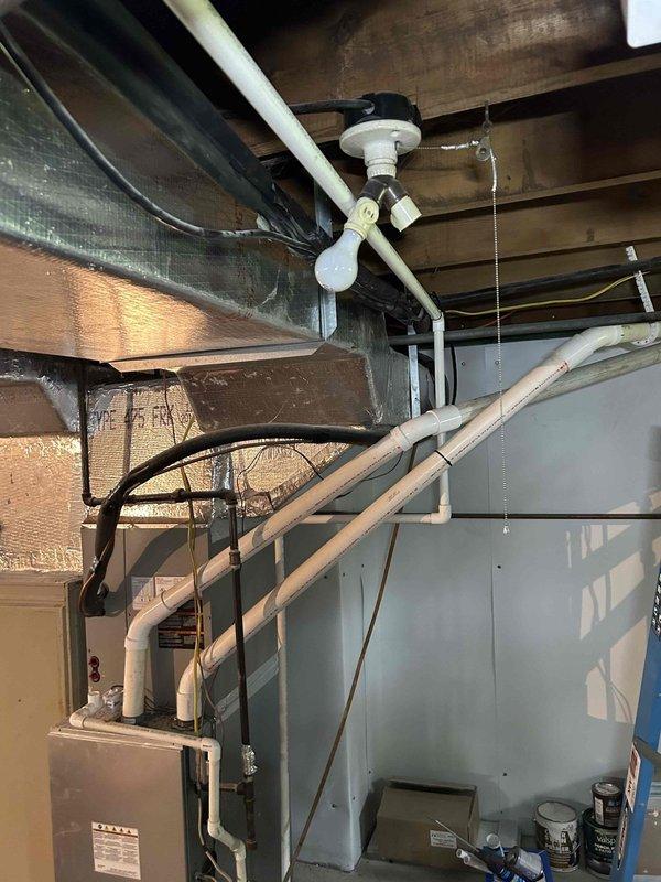 Responded to no heat call on mini split system less than 10 years old. Upon inspection, located cracked drain tubing in basement that was previously identified as running from upstairs mini split head unit down through wall cavity to condensation pump for main floor system. Repaired damaged drain line section in basement to eliminate water leakage on basement floor and restore proper condensate drainage to pump. System tested and verified operational with proper drain function restored.