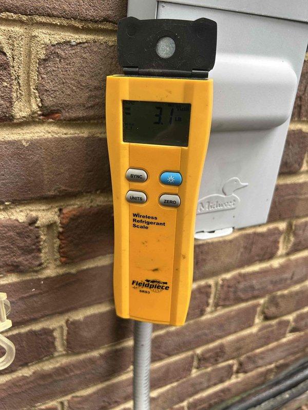 Responded to report of icing on furnace component while both heating and cooling systems remained operational. Upon arrival, performed comprehensive system inspection of outdoor condensing unit and refrigerant circuit. Utilized calibrated refrigerant scale to verify system charge levels and diagnose potential causes of ice formation. Inspected condenser unit exterior components, refrigerant lines, and electrical connections. Assessed R-410A refrigerant specifications and system performance parameters. Documented equipment condition with photographic evidence showing outdoor unit installation, refrigerant line routing, and measurement equipment readings. Systems found operating within normal parameters at time of inspection with no active icing present on accessible components.