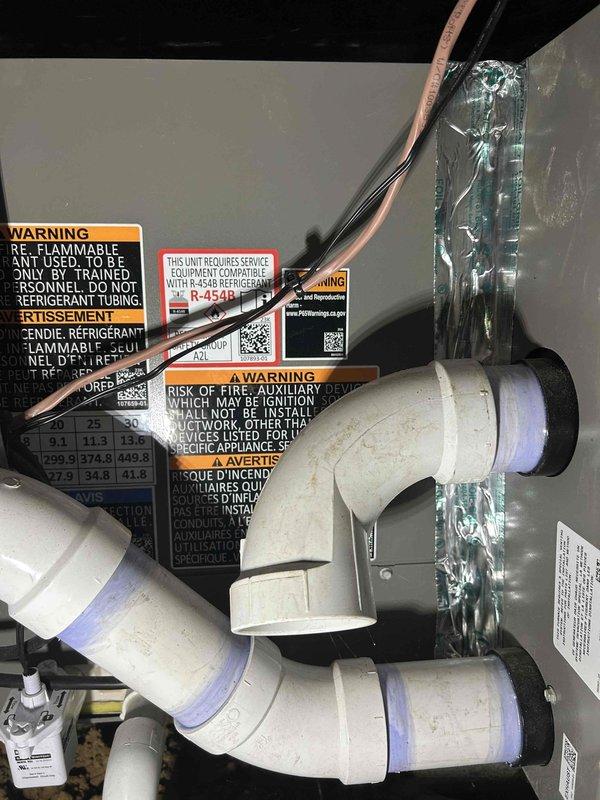 Completed routine AC tune-up on a one-year-old system located in crawlspace. Addressed customer concern regarding popping noise from vent when unit shuts off. Performed standard maintenance inspection of gas furnace and air conditioning components, including examination of R-454B refrigerant system, PVC condensate drain lines with visible purple primer at joints, copper refrigerant lines, and ductwork. Verified system operation and documented equipment condition. Noted dual filtration setup with filter rack at unit in crawlspace and additional filters at floor registers inside home.