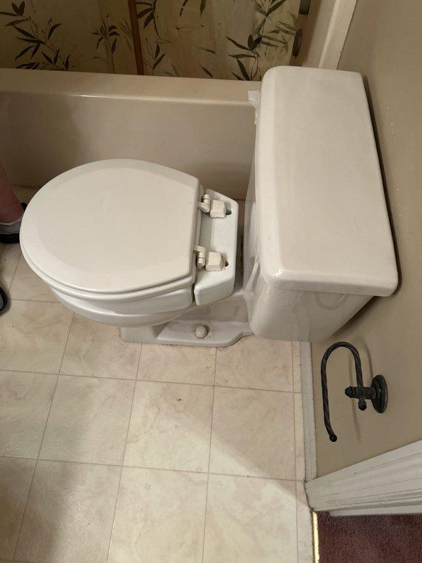 Performed comprehensive camera inspection of plumbing system to assess multiple issues. Documented kitchen sink drain assembly showing dual-basin PVC trap configuration with visible age-related deterioration and intermittent dishwasher connection leaks. Inspected bathroom toilet exhibiting water leakage around base with supply currently shut off, indicating probable wax ring failure requiring replacement. Evaluated exterior hose bibb positioned too low for standard hose connection, requiring relocation or adjustment for proper functionality.