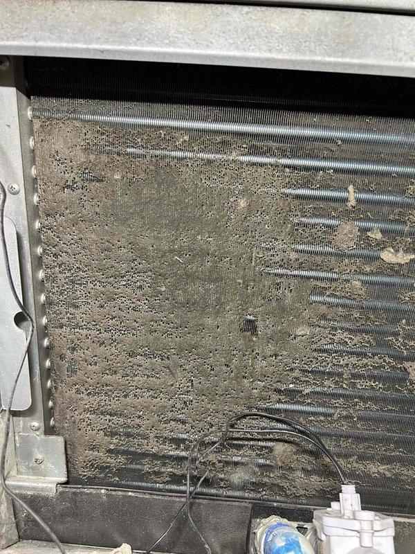 Responded to no cooling complaint on commercial HVAC unit in building 6. Upon inspection, found condenser coils completely blocked with heavy accumulation of dirt, dust, and debris, severely restricting airflow and preventing proper heat exchange. Condenser screen and mesh filters also heavily clogged with sediment buildup. Cleaned condenser coils and removed all debris from unit. Verified proper airflow restoration and system operation. Unit returned to normal cooling capacity.