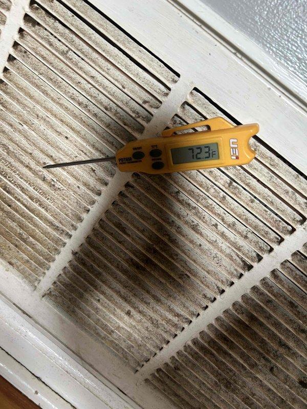 Responded to no cooling complaint on gas furnace/AC system with indoor unit located in hallway. Upon arrival, system was blowing warm air. Performed diagnostic evaluation and discovered heavily soiled return air grille restricting airflow, with return air temperature measuring 72.3°F. Inspected crawlspace area and observed underfloor mechanical components, plumbing infrastructure, and fiberglass insulation between floor joists. Identified compromised airflow as primary cause of inadequate cooling performance. Recommended immediate filter replacement and return grille cleaning to restore proper system operation and airflow requirements.