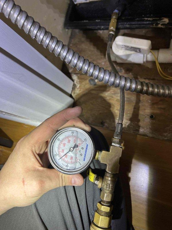 Responded to no-cooling complaint on 10+ year old geothermal system located in upstairs closet. Upon arrival, found condensate drain pan overflowing, causing unit to shut down on safety. Customer reported having to manually drain pan to restore operation. Inspected condensate drainage system and identified blockage in primary drain line preventing proper water evacuation. Cleared obstruction from drain line using appropriate tools and verified proper flow. Checked condensate pump operation and confirmed functionality. Tested system pressures with gauge to verify refrigerant charge and proper operation of geothermal loop. Monitored unit through complete cooling cycle to ensure condensate draining properly and no safety shutdowns occurring. System restored to normal operation with condensate removing as designed.