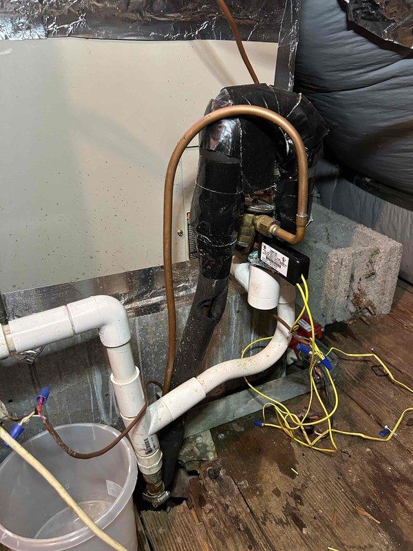 Responded to no cool complaint on 8-year-old electric system with indoor units in basement and garage. Upon arrival, thermostat set to 74°F but reading 78°F on main level, with upstairs temperatures reaching 81°F. Performed comprehensive system diagnostics including temperature measurements at supply registers, which recorded 61.8°F at floor vent indicating inadequate cooling delivery. Inspected compressor unit and refrigerant lines in attic/crawl space, noting U-shaped copper line configuration and electrical connections. Evaluated condensate drain installation and discussed relocation options to address winter freezing issues and summer dripping onto garage floor. Assessed ductwork system and airflow distribution to identify factors contributing to inadequate temperature maintenance and differential between floors. Provided findings on system performance, duct design considerations, and recommendations for resolving temperature imbalances throughout the home.