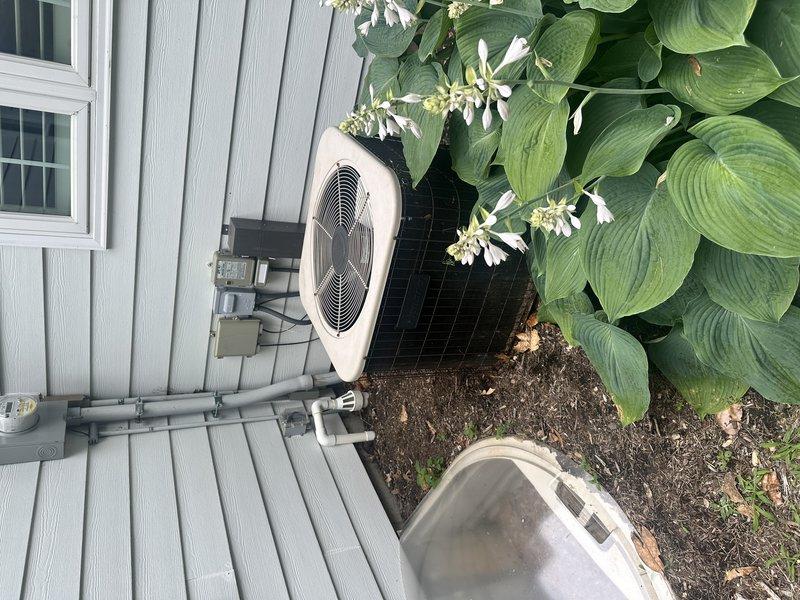 Completed estimate for full HVAC system replacement on 25-year-old air conditioning unit with indoor air handler located in laundry room. Assessed existing grey metal air handler with flexible black ductwork and outdoor condensing unit with beige top housing positioned on composite decking against exterior wall. Customer requested ASAP replacement with no brand preference and will not require financing options.