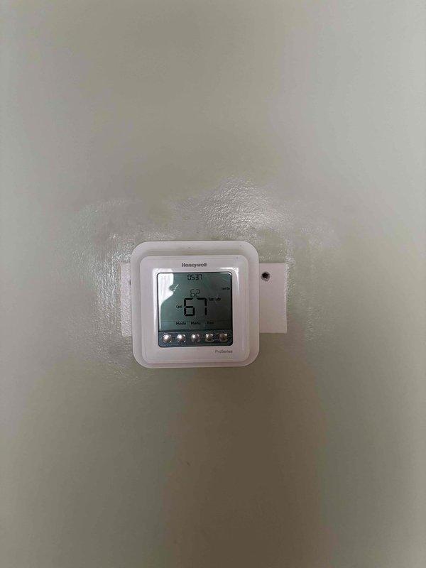 Completed preventive maintenance tune-up on heat pump system with air handler located in attic accessible via pull-down stairs. Performed comprehensive system diagnostics on outdoor unit using refrigerant manifold gauge, confirming R410A refrigerant charge with pressures reading 117.3 psig low side and 229.0 psig high side, with superheat and subcooling measurements recorded. Verified thermostat operation and programming on Honeywell ProSeries digital control set to 67 degrees.
