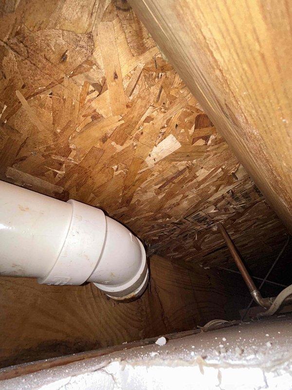 Responded to water leak investigation in 32-year-old home where ceiling water staining was reported in a single area. Accessed attic/crawl space above affected ceiling and performed thorough inspection of plumbing system components. Located white PVC pipe running through the space with visible joint connections and couplings. Examined all accessible piping, connections, and surrounding OSB sheathing for signs of active leakage, moisture damage, or failed seals. Inspected roof framing members and decking material in vicinity of reported stain to determine source of water intrusion. Documented existing conditions including pipe routing, joint locations, and any visible discoloration on structural materials. No additional affected areas or secondary leak symptoms were identified during inspection. Photographed plumbing configuration and surrounding area for record purposes.