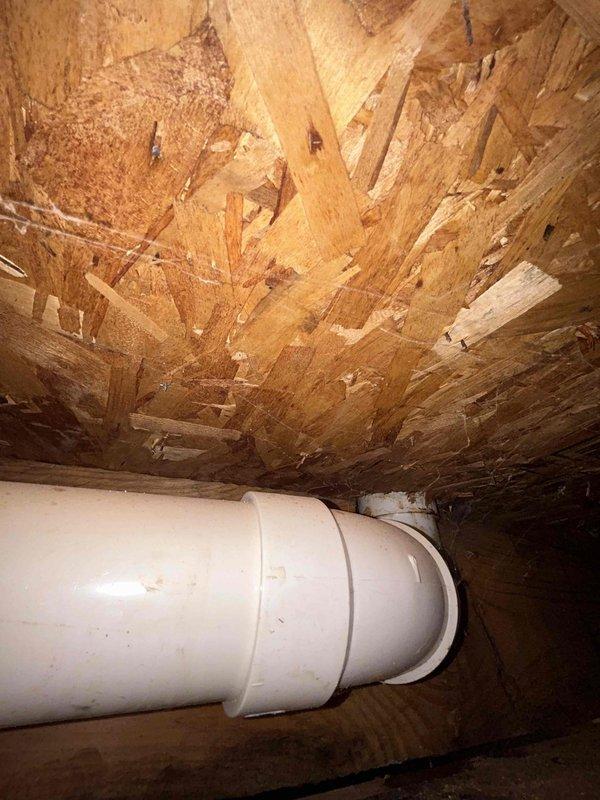 Responded to water leak investigation in 32-year-old home where ceiling water staining was reported in a single area. Accessed attic/crawl space above affected ceiling and performed thorough inspection of plumbing system components. Located white PVC pipe running through the space with visible joint connections and couplings. Examined all accessible piping, connections, and surrounding OSB sheathing for signs of active leakage, moisture damage, or failed seals. Inspected roof framing members and decking material in vicinity of reported stain to determine source of water intrusion. Documented existing conditions including pipe routing, joint locations, and any visible discoloration on structural materials. No additional affected areas or secondary leak symptoms were identified during inspection. Photographed plumbing configuration and surrounding area for record purposes.