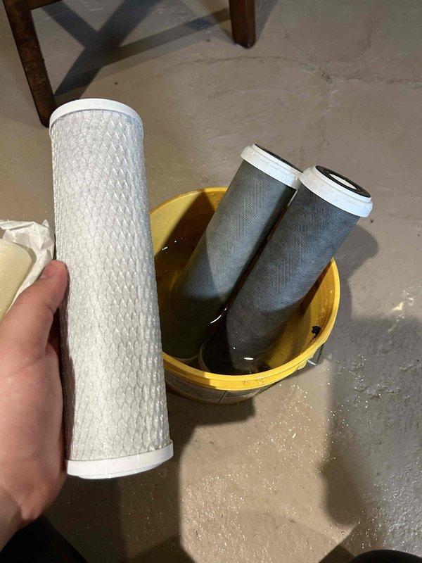 Completed filter cartridge replacement on APEC ROES-PH75 reverse osmosis water treatment system. Removed and replaced three-stage pre-filtration cartridges including sediment and carbon block filters, restoring system to optimal operating condition.