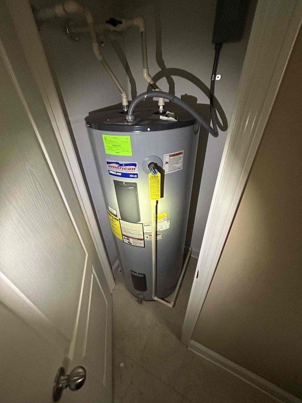 Performed routine plumbing inspection of residential water heater system. Inspected American brand water heater unit, verified proper installation of inlet/outlet connections, PVC piping, pressure relief valve, and electrical components. All components found in good working condition with no visible leaks, corrosion, or safety concerns identified.