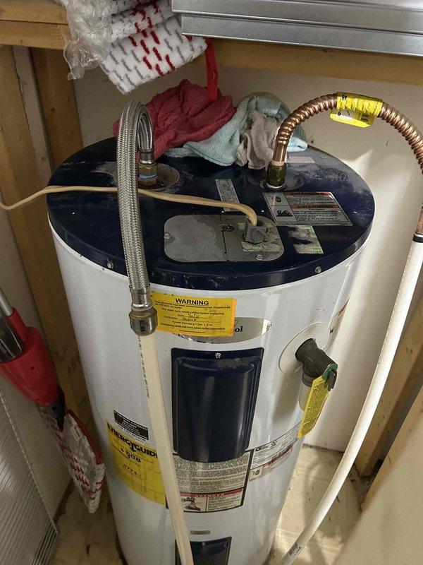 Responded to steady water leak at hot water heater outlet connection. Upon inspection, identified active leak at hot water outlet piping on top of residential water heater unit. Assessed plumbing connections including braided flex supply line and copper discharge piping with insulation. Documented existing conditions showing water heater installation in utility closet space with standard residential connections. Leak originated from outlet fitting requiring immediate attention to prevent continued water damage and ensure proper system operation.