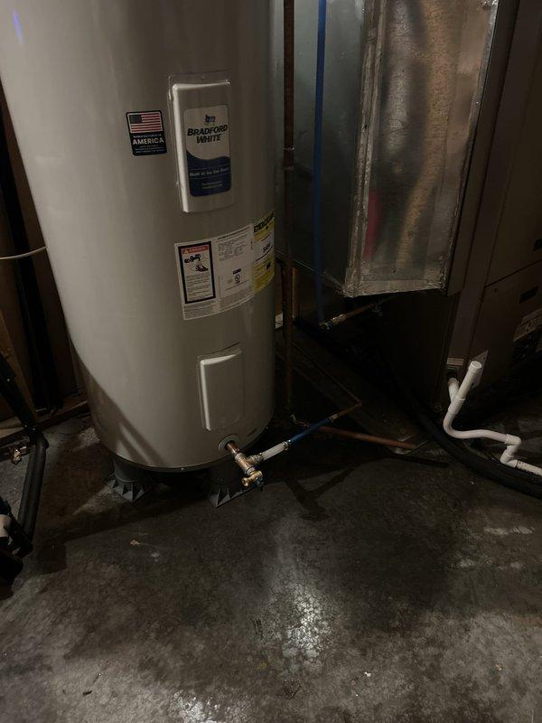 Responded to service call for 50-gallon standard electric water heater exhibiting burnt smell, visible burnt marks on lower heating element, and water leakage at base of unit. Upon inspection, confirmed unit was over 10 years old with significant deterioration and moisture damage visible on concrete floor surrounding the Bradford White water heater. Due to age of unit, compromised lower element, active water leak, and potential safety concerns from burnt electrical components, recommended and performed complete water heater replacement. Removed existing failed unit, installed new 50-gallon electric water heater with proper electrical connections and plumbing hookups including copper supply lines and appropriate safety devices. Tested new installation for proper operation, verified no leaks at connections, and confirmed adequate hot water production. Removed old unit from premises and left work area clean.