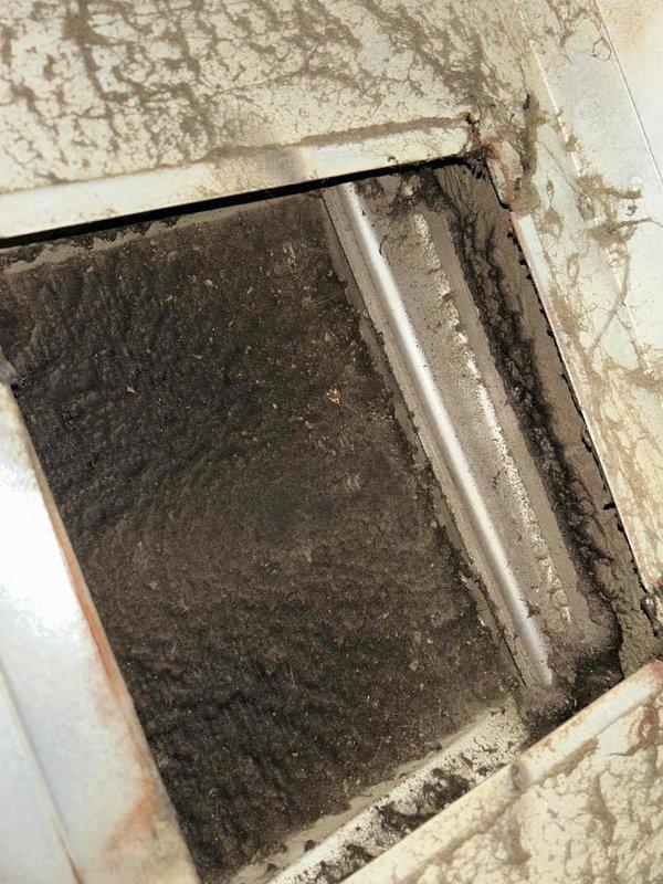 Responded to report of grinding noise from 5-year-old air conditioning unit located in crawl space. Upon inspection, discovered severely clogged air return filter and blower wheel assembly heavily coated with dust and debris accumulation. Identified excessive dust buildup on blower wheel blades and housing as primary cause of grinding noise and restricted airflow. Cleaned blower assembly, replaced air filter, and verified proper system operation. Unit returned to normal operation with no abnormal sounds detected. Recommended regular filter maintenance to prevent future issues.
