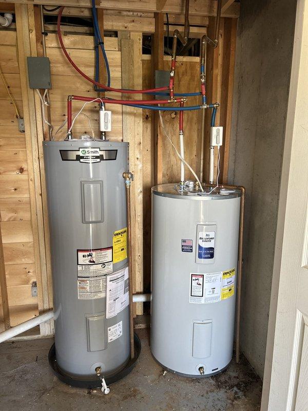 Installed two 50-gallon Bradford White electric water heaters in parallel configuration in utility room with exposed stud walls. Completed all necessary plumbing connections using copper pipe and PEX tubing with brass fittings, installed three safety shut-off valves for system isolation and emergency protection, and connected electrical supply via conduit to junction box. Verified proper operation of both units and ensured all connections met code requirements.