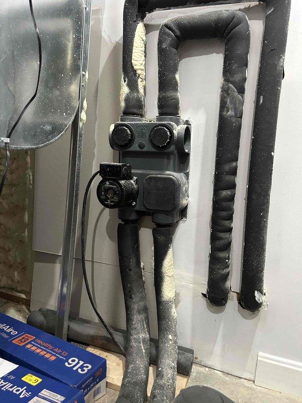 Responded to no cooling call on geothermal heat pump system with 6-degree temperature differential. Upon arrival, system was running but failing to maintain setpoint of 72°F with indoor temperature reading 78°F. This was a return visit for the same issue that had been addressed previously on 5/12. 

Performed diagnostic testing on indoor air handler unit and inspected geothermal loop connections. Utilized digital multimeter to measure electrical readings at control board and compressor circuit, obtaining voltage reading of 13.52V during testing. Examined reversing valve assembly and insulated refrigerant lines for proper operation. Inspected black insulated piping configuration and junction connections on geothermal loop system for signs of flow restriction or air pockets.

Checked capacitor values, control board functions, and verified proper electrical connections throughout air handler. Evaluated system pressures and temperatures to determine if issue was related to ground loop perf