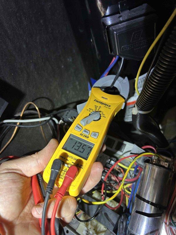 Responded to no cooling call on geothermal heat pump system with 6-degree temperature differential. Upon arrival, system was running but failing to maintain setpoint of 72°F with indoor temperature reading 78°F. This was a return visit for the same issue that had been addressed previously on 5/12. 

Performed diagnostic testing on indoor air handler unit and inspected geothermal loop connections. Utilized digital multimeter to measure electrical readings at control board and compressor circuit, obtaining voltage reading of 13.52V during testing. Examined reversing valve assembly and insulated refrigerant lines for proper operation. Inspected black insulated piping configuration and junction connections on geothermal loop system for signs of flow restriction or air pockets.

Checked capacitor values, control board functions, and verified proper electrical connections throughout air handler. Evaluated system pressures and temperatures to determine if issue was related to ground loop perf