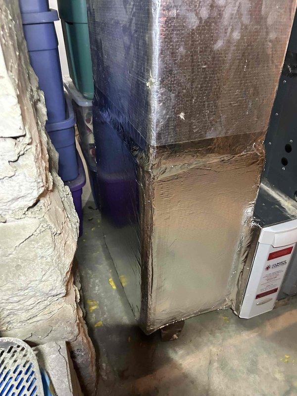 Replaced damaged ductwork section in basement mechanical room using two sheets of ductboard to fabricate a 12x22 inch rectangular duct with end cap. The new duct section was installed to replace deteriorated ductwork that showed significant dust accumulation, staining, and wear, restoring proper airflow and system efficiency.