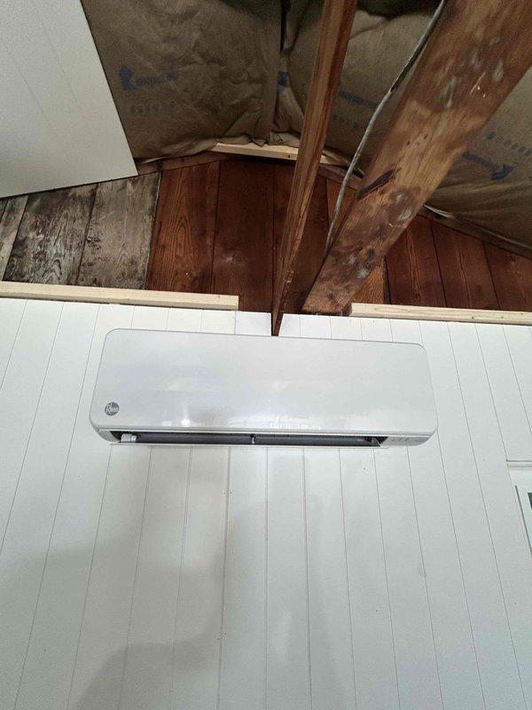 Completed installation of customer-provided mini-split system in detached garage, mounting both indoor and outdoor units. The indoor air handler was wall-mounted on finished beadboard paneling in the upper level space with exposed structural framing. All refrigerant lines, electrical connections, and condensate drainage were properly installed and tested for functionality, with the system confirmed operational upon completion.