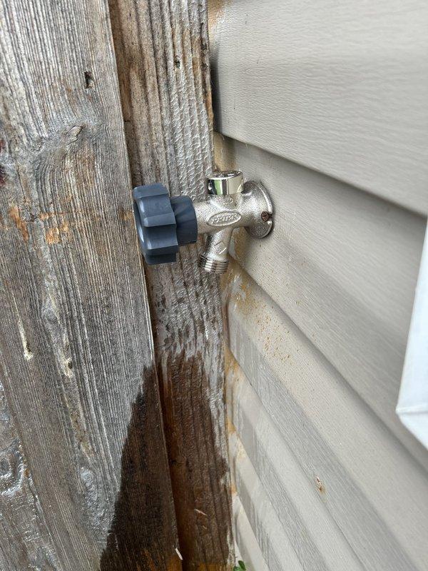 Responded to water leak emergency where outdoor hose bib had separated from interior copper feed line. Upon arrival, found temporary cap installed on exposed pipe through access hole in interior wall. Diagnosed complete failure of spigot connection point within wall cavity. Removed temporary cap and damaged section of copper supply line. Installed new brass hose bib with proper shutoff valve and secured connection using compression fittings. Tested system under full pressure to verify watertight seal and proper operation of shutoff mechanism. Confirmed no additional leaks present in surrounding plumbing. Access opening left available for property owner to arrange drywall repair and finishing.