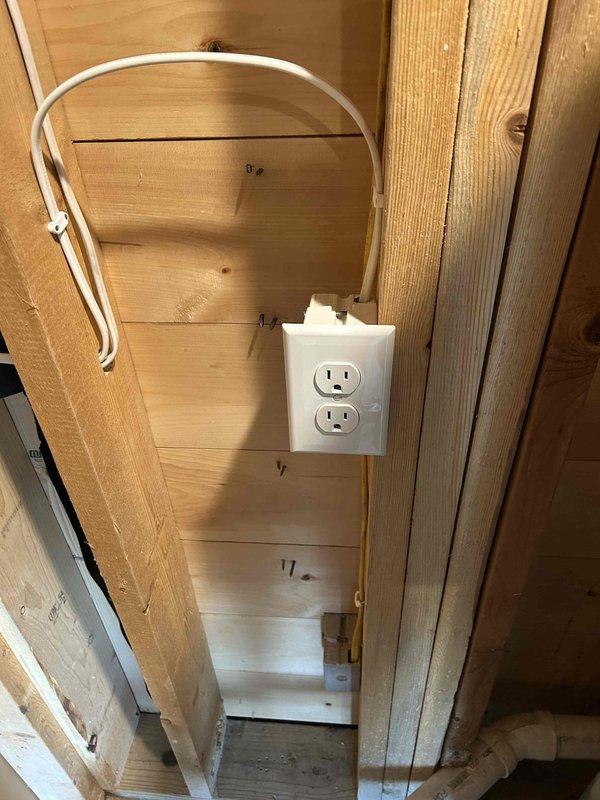 Installed dedicated 120V duplex receptacle outlet in unfinished utility area to provide power for dual water shut-off valves servicing two water heaters. Mounted outlet box on exposed wall framing and ran electrical cable from power source to new outlet location. Completed installation per specifications with all wiring properly secured to structural members.