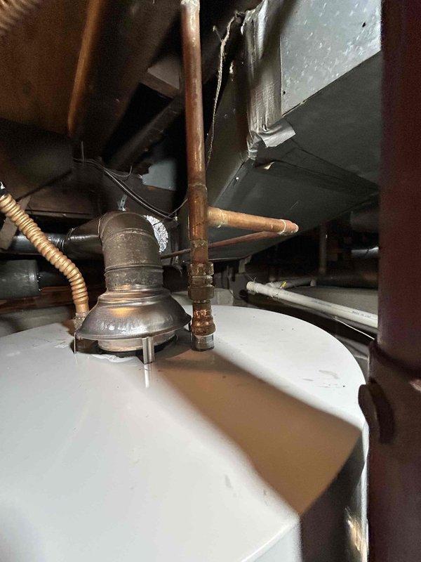 Replaced 40-gallon gas water heater in basement utility area. Removed existing unit and installed new tanked water heater with proper copper piping connections, pressure relief valve, and gas line hookup. Verified proper combustion with blue flame present and confirmed all connections are secure and system is operational.