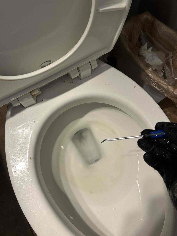 Responded to service call for sump pump running continuously with steam visible from discharge water and upstairs toilet flushing inconsistently. Inspected 2-year-old sump pump in basement and found unit operating non-stop, indicating potential float switch malfunction or check valve failure causing pump to cycle without shutting off. Diagnosed upstairs bathroom toilet and performed inspection of flush mechanism and internal components using specialized plumbing tools. Documented condition of toilet bowl showing mineral deposits and staining consistent with inconsistent flushing patterns. Identified issues requiring repair to restore proper operation of both fixtures.