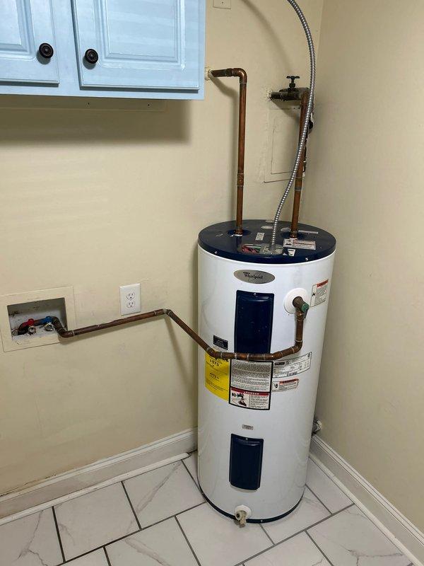 Conducted plumbing estimate for tankless water heater replacement of existing 40-gallon Whirlpool tank unit located in lower level laundry room. Assessed current installation including copper supply lines, electrical connections, and venting requirements, while also evaluating feasibility for whole house water filtration system integration with outdoor water meter assembly.