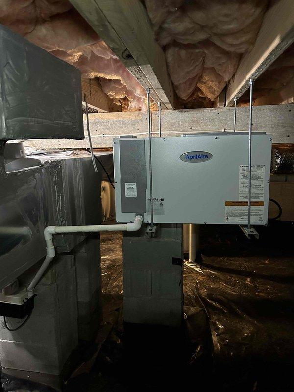 Returned to property to address crawl space flooding issues and equipment relocation. Replaced shorted condensate pump that had failed due to water exposure and mounted new unit on cinder block support column to elevate above ground level. Relocated AprilAire dehumidifier from garage back to crawl space and secured unit to floor joists using metal straps per customer preference, eliminating ground contact and reducing future flood risk. Verified proper drainage connections and electrical operation of both units before completing installation.