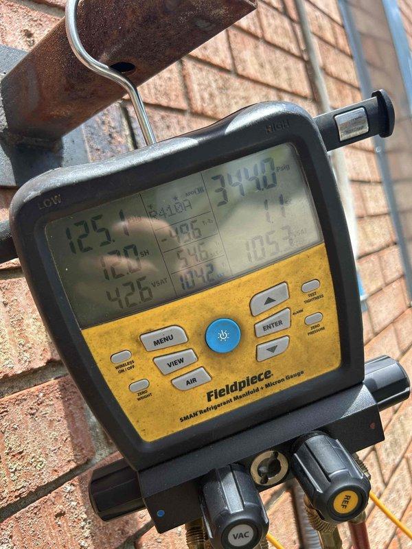 Responded to no cooling complaint on 7-year-old electric heat pump system serving lobby area. Upon arrival, found space temperature at 77°F with thermostat set to 72°F and unit blowing warm air. Indoor unit located in utility closet within large garage area, outdoor unit positioned at back of building. Performed diagnostic testing using digital manifold gauges and temperature probes on rooftop unit. Measured refrigerant pressures and temperatures at suction and liquid lines. Supply air temperature reading confirmed warm air discharge at 77.3°F from insulated ductwork. System showed inadequate cooling capacity and inability to meet thermostat setpoint demand.