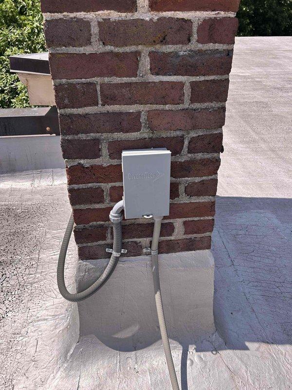 Responded to no cooling complaint on dual Mitsubishi mini-split system with indoor units located in attic. Performed diagnostic evaluation of both outdoor condensing units and indoor air handlers. Inspected refrigerant lines, electrical connections, and control wiring at exterior units mounted on rooftop and at brick wall location. Verified power supply to both systems and checked condensate drainage. Assessed overall system operation and identified necessary repairs to restore cooling function to both zones.