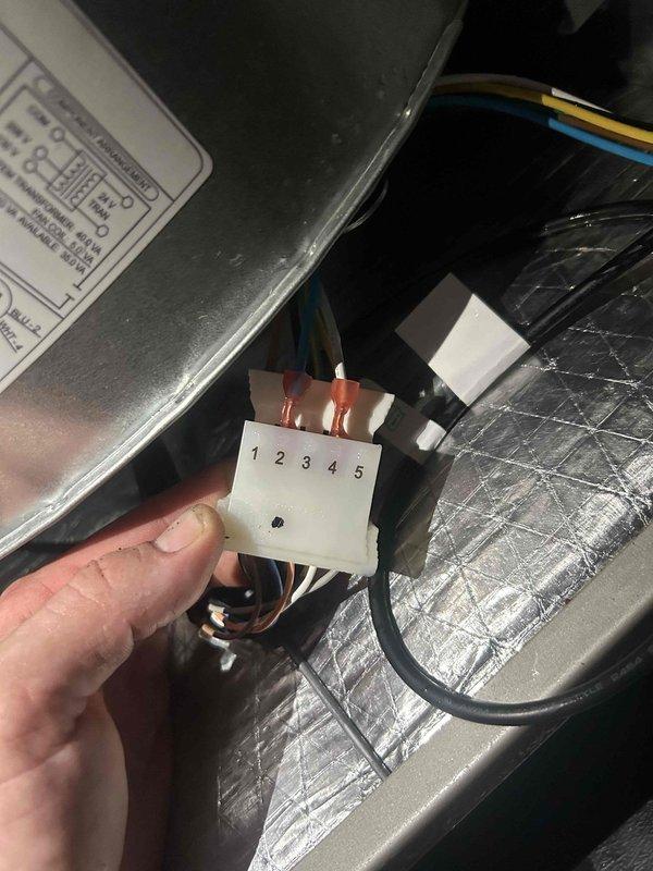 Responded to service call for newly installed AC system experiencing poor cooling and weak airflow throughout home. Upon inspection, discovered severe frost and ice buildup on evaporator coil, indicating restricted airflow or refrigerant issue. Documented frozen coil condition and examined electrical connections at terminal block. Identified improper wiring configuration on five-point terminal connector that was affecting system operation. Corrected wiring connections per manufacturer specifications to resolve cooling deficiency and restore proper airflow to residence.