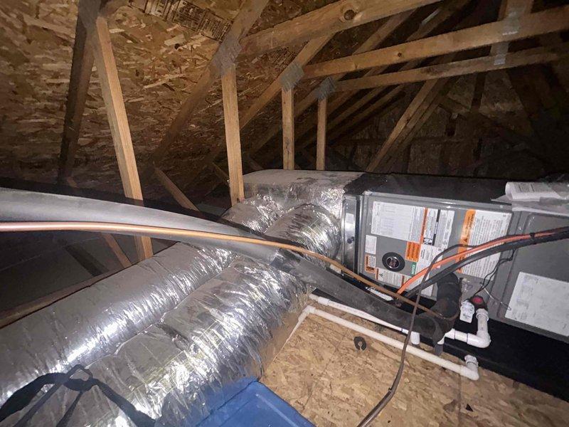 Completed full residential HVAC system installation featuring a RUUD 2.5 ton two-stage heat pump system rated up to 15.2 SEER2 (model RP14AY30AJ2NA). Installed RUUD air handler (model RH2TY3617STANNJ) in attic space with proper mounting and support platform. Integrated RUUD 15kW heat kit (model RXBH-1724A15J-B) for supplemental heating capacity. Installed new digital thermostat for system control and programming.

Removed and properly disposed of existing HVAC equipment per code requirements. Set outdoor heat pump unit on new concrete pad with snow legs for elevation and drainage. Installed electrical disconnect box and whip kit to provide proper electrical service to outdoor unit. Ran and insulated refrigerant lines between outdoor heat pump and indoor air handler, including installation of refrigerant line filter for system protection.

In attic installation, configured air handler with transitions to connect to existing ductwork system. Installed standard-sized air filter rack for e