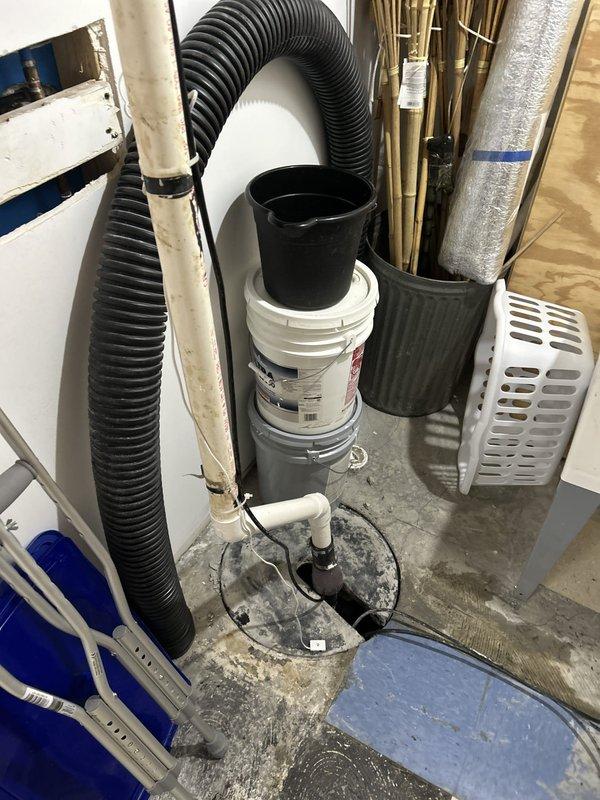Removed failed sump pump assembly from existing concrete sump pit and installed new replacement unit with purple translucent discharge chamber and PVC piping components. Verified proper electrical connections, tested pump operation, and confirmed adequate drainage function in basement mechanical room.