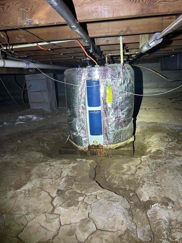 # HVAC Service Report - No Cooling Issue

Responded to service call for heat pump system blowing air but not cooling. Upon arrival, performed visual inspection of outdoor condensing unit and indoor air handler located in crawlspace.

Outdoor unit inspection revealed significant airflow restriction due to heavy vegetation growth surrounding and obstructing the condenser coil and ventilation grilles. Dense weeds and plant material had accumulated around the base and sides of the unit, preventing proper heat exchange and airflow. Cleared vegetation from around condensing unit perimeter to restore adequate clearance for proper operation.

Inspected indoor air handler in crawlspace. Unit appeared operational with no visible damage or disconnected components. Verified electrical connections and refrigerant lines were secure.

Educated homeowner on importance of maintaining minimum 24-inch clearance around outdoor unit and regular vegetation management to prevent future airflow restrictions. 