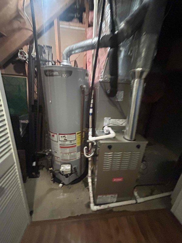 Completed full HVAC system replacement in residential basement utility area. Removed and disposed of existing equipment. Installed new Bryant 70,000 BTU 80% efficiency single-stage gas furnace (model 800SB36070M17) with Bryant 3-ton 14.3 SEER2 single-stage air conditioning system and matching evaporator coil (model WCVAVA3617XMA). 

Installed outdoor condensing unit on new equipment pad with electrical whip kit and disconnect box. Ran and insulated refrigerant lines with filter drier installation. Connected evaporator coil to existing ductwork with proper transitions and installed standard-sized air filter rack. Installed SS2 coil drain safety water sensor for secondary drain pan protection.

Connected furnace to existing flue piping with proper venting. Installed flexible gas line connector with gas shut-off switch and flame roll-out protection for safety compliance. Installed electrical shut-off switch for service accessibility. Upgraded to digital thermostat for improved system cont