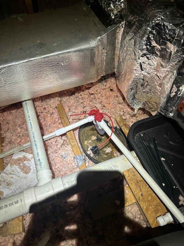 Responded to callback for water leak in second-floor bedroom originating from newly installed upstairs HVAC unit. Upon arrival, inspected ceiling damage showing diagonal crack with water staining and discoloration. Accessed attic space above affected area and located source of leak at condensate drain line. Found improperly secured PVC drain connection at air handler, allowing water to overflow onto insulation and ceiling joists. Corrected drain line installation, secured all connections, and verified proper pitch for drainage. Tested condensate system under full operation to confirm leak resolution. Documented ceiling damage with photos for repair coordination. System now operating properly with no active leaks detected.